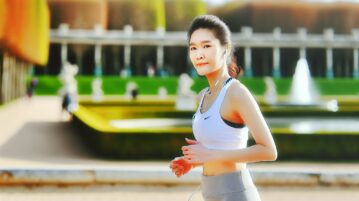 Une personne en tenue de sport, en plein jogging dans un parc, avec un air serein et concentré sur son visage.
