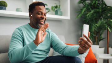 un homme fait coucou à son smartphone lors d'un appel vidéo