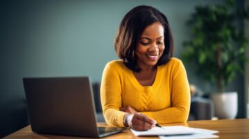 une femme regarde ses comptes avec le sourire